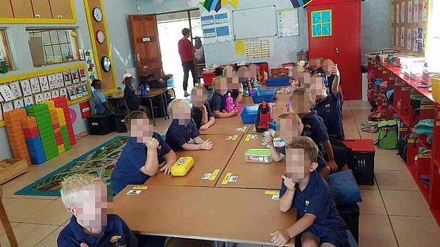 Black and white children sit separately on their first ever day at school in South Africa